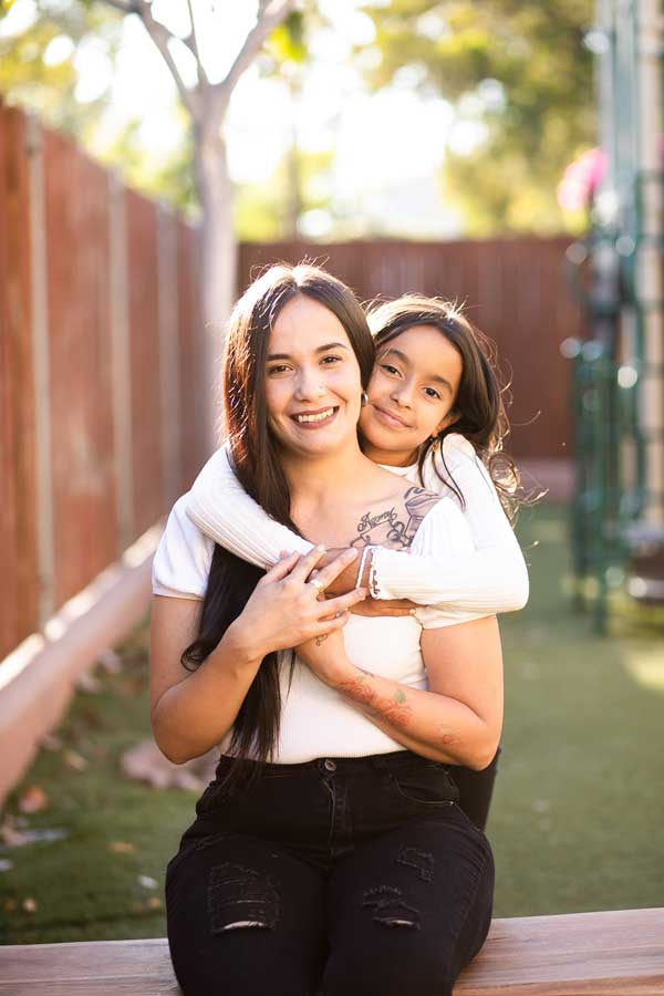 mother and Daughter embracing outdoors